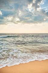 Fototapeta na wymiar Tropical beach with horizon over ocean water at sunset.