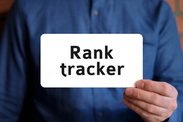 Rank tracker - text on a white sign in the hand of a man in a blue shirt