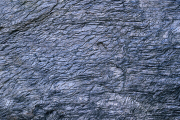 Crumpled surface of slate for backdrop. Gold-antimony ore. Color - Ship Cove, Hue Blue. Metallic shine. Dispersion of golden particles.