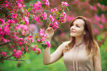 Naklejka premium portrait of a beautiful young woman with make-up near a tree with flowers