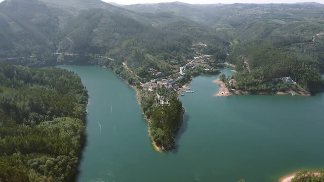 Aerial view of the mountain village of Dornes in Portugal. Scenic view from above on the peninsula and lake or river in the mountains.