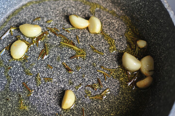fried garlic with rosemary in a pan