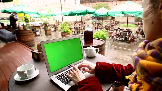 Female hands typing on laptop with chroma key green screen outdoor with modern exterior on background. Internet connecting wifi 5G. Online chat communicating app. Networking business people lifestyle.