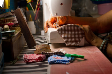 Hand of old woman pull a thread to sewing a Hygienic mask for prevention of corona virus or air pollution.