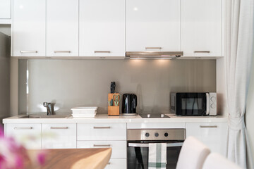 Interior design of kitchen in luxury villa, apartment feature kitchen counter, refrigeratpr, oven, hood and microwave