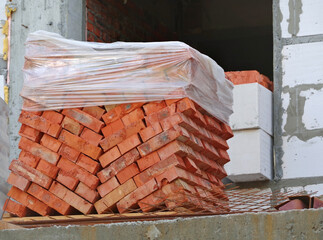 Red bricks stacked on wooden pallet