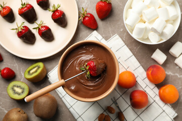 Composition with ingredients for chocolate fondue on gray table. Cooking fondue