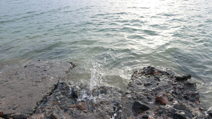 Spindrift at sea with splash of water against the stone shore