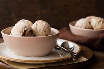 Chocolate ice cream scoops  in white bowl, chocolate and mint decoration. Summer food concept with copy space.