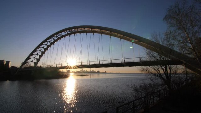 Silhouette of jogger running through sun on Mimico bridge. Toronto sunrise.