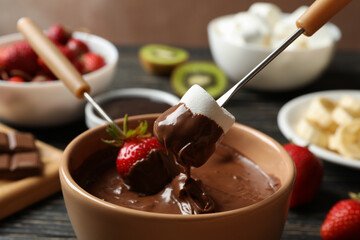 Marshmallow and strawberry in chocolate, close up. Chocolate fondue