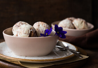 Chocolate ice cream scoops  in white bowl, chocolate and mint decoration. Summer food concept with copy space.