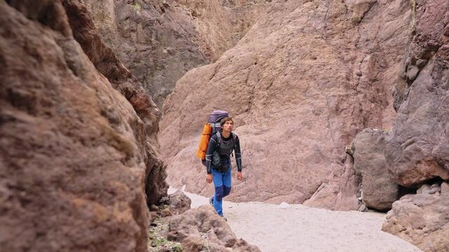  slow motion long shot male man boy profile tracksuit shirt shorts breeches pants jeans leggings rock red formations geology geological valley scenery cliff landscape mountain scenic  shadow shade loo