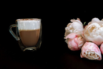 Glass mug of carucchino with a double bottom and peonies .