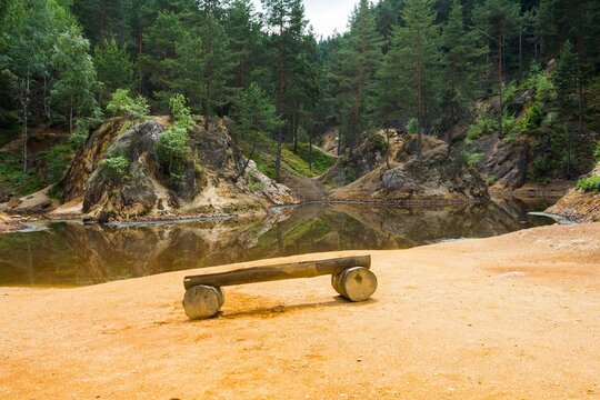 Wooden bench on sand in front of the purple lake -  Kolorowe Jeziorka "Colourful lakelets", Poland 