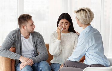 Professional Psychologist Comforting Unhappy Wife During Family Therapy In Office