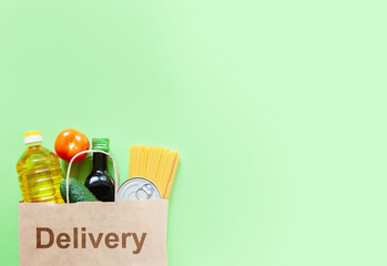 Delivery box with various products. Food set in a box on green background. Free space for text copy space