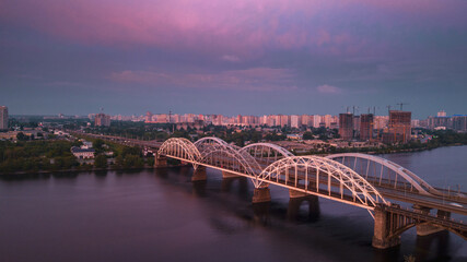 Fototapeta na wymiar aerial city view, luminous buildings and bridge at sunset. Drone shot.