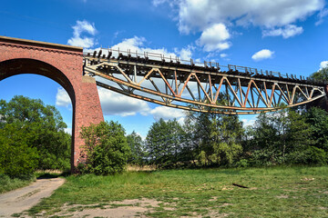 Metal construction of a destroyed railway viaduct against the sky in Poland.
