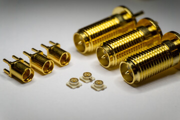 Close-up of symmetric aligned gold plated uFL, MMCX micro precision radio connector partial focus...