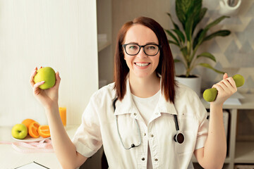 Beautiful doctor nutritionist woman sitting at work, having a feast in a bright office with an...