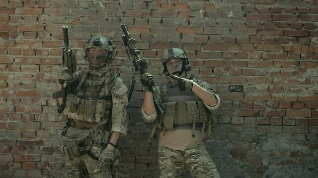 Airsoft men with gun stand happy after fight. Training to fight in urban territory