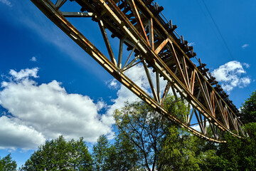 Metal construction of a destroyed railway viaduct against the sky in Poland.