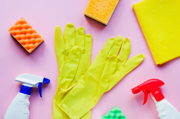 Detergents and cleaning accessories in pink color. Cleaning service concept. Flat lay, Top view.