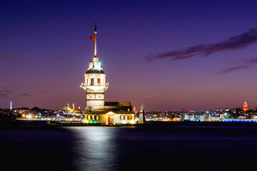 Naklejka na ściany i meble Cityscape of historic Istanbul with the illuminated Maiden's/Leander's Tower and the skyline in the evening. Uskudar, Istanbul, Turkey 