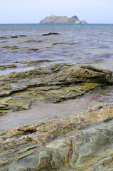 Fototapeta na wymiar plage et vue sur le rocher et phare de cap corse