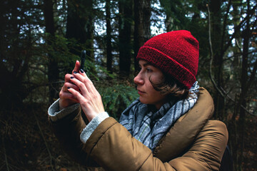 Young woman in autumn forest takes pictures on the phone. Backpacking in Caprpathian mountains  - 355001039