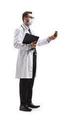 Male doctor wearing a protective face mask and holding a bottle of pills