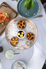 Sea urchin caviar lies on ice. Beautiful plate. Seafood restaurant. White tablecloth. Caviar sauce with raw quail eggs. Fresh seafood. The table of the reservoirs.