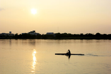 Man boating on the lake in sunset time