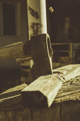 rusty ax stuck in a dry log on a sunny day