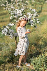 girl in nature. She's wearing a light dress and flowers in her hair