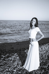 Attractive woman in white dress on the beach