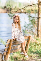 beautiful girl is sitting on a bench on the beach. Summer photo in nature