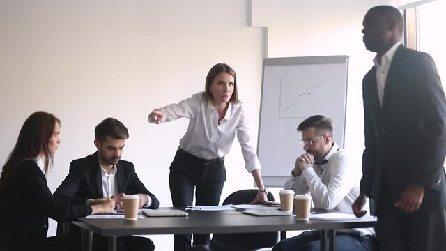 Angry woman ceo team leader firing unprofessional incompetent black man employee for bad results asking to leave during group meeting with hand gesture, racial discrimination at work dismissal concept