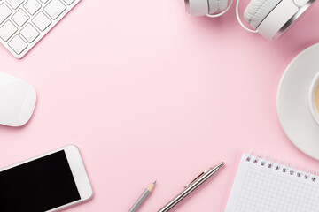 Pink workplace with computer, smartphone and coffee