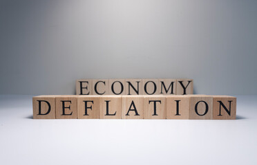 Deflation text from wooden cubes. Spot light in the studio and white background.