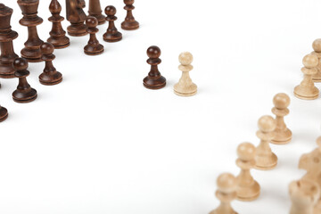 black and white pawn opposite each other on a white background. beginning of a chess game. game...