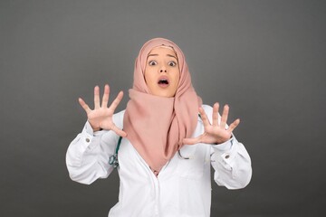 Dissatisfied doctor female model frowns face, has disgusting expression, shows tongue, expresses...