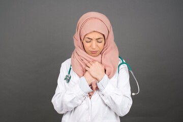 Sad pretty muslim doctor girl feeling upset while spending time at home alone. Beautiful young...