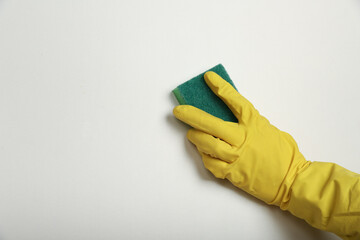 cleaner's hand in glove holding sponge on white background