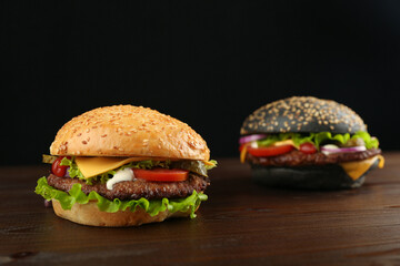 two classic american burgers on dark wood background