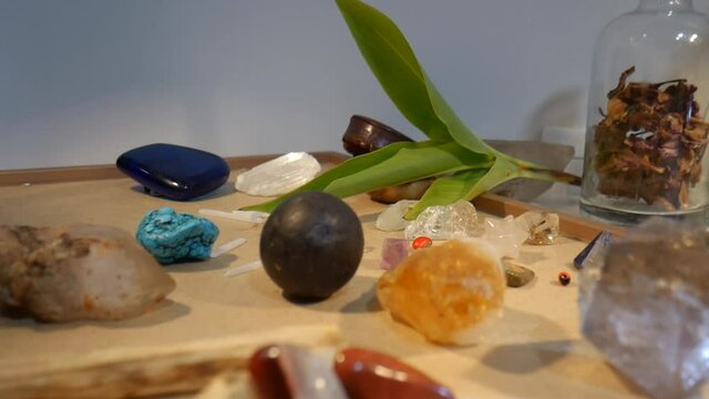Yellow Citrine Crystal and Real Peruvian Meteorite Centered in Foreground used for Meditation Energy Work Yoga Reiki Healing Lightwork Other Crystals and Plants in Background in 4k