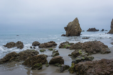 Fototapeta na wymiar rocks on Malibu beach at low tide on a gloomy morning