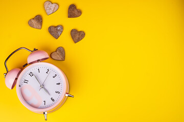 Detail close up of the old pink vintage alarm clock on colour background with free copy space.