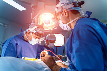 Medical team performing surgical operation in bright modern operating room. Medical devices for neurosurgery.